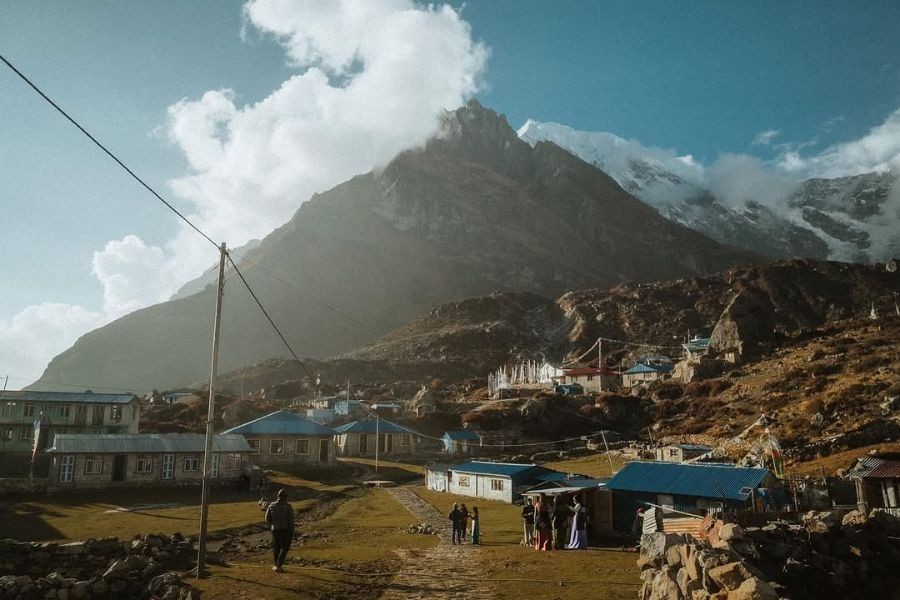 Mountain village settlement with blue-roofed buildings and dramatic peak